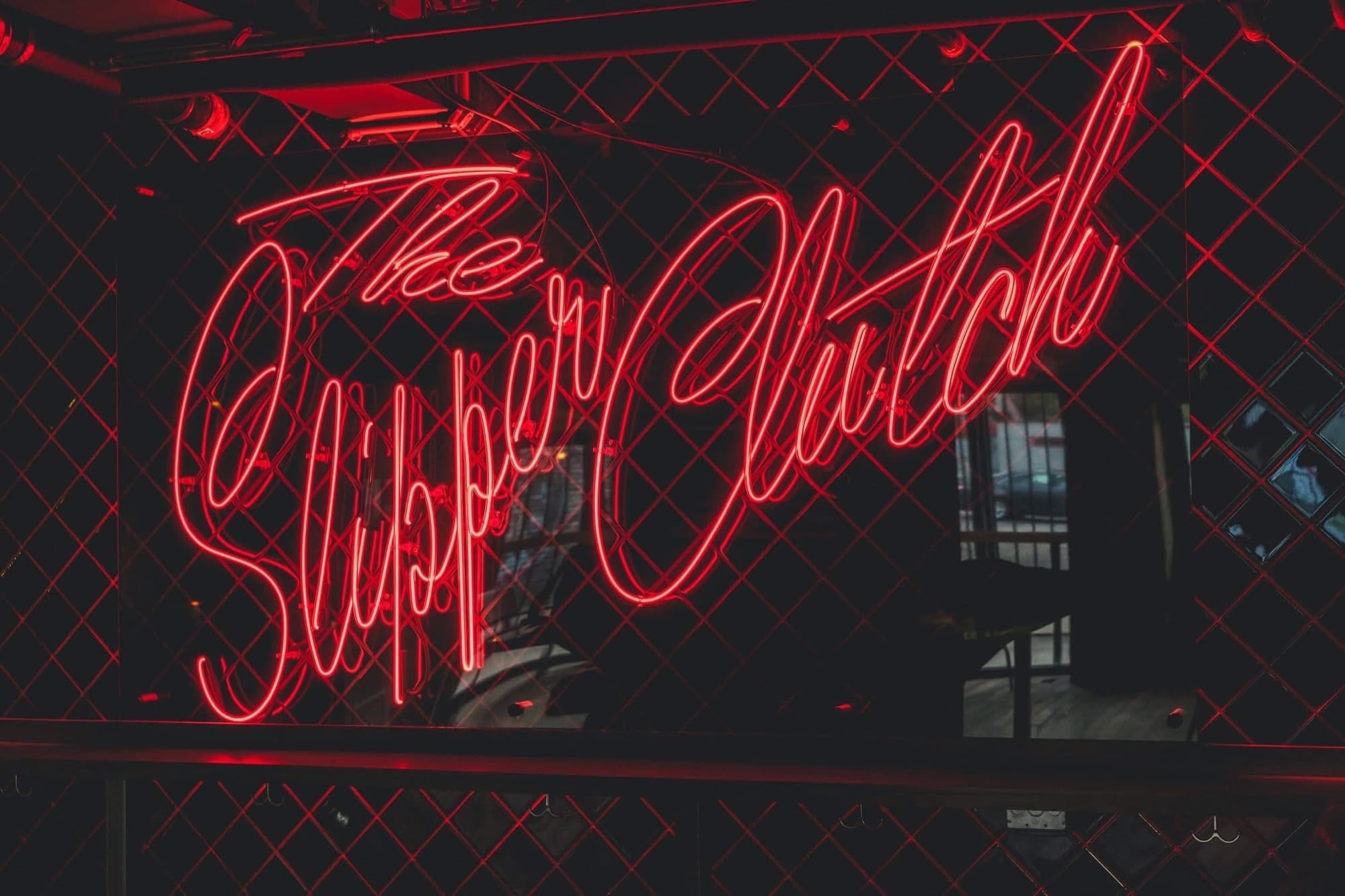 The Slipper Clutch site hero, neon signage in a dark bar interior